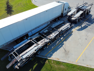 A car carrier trailer transporting several vehicles on a highway.