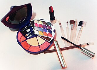 A tabletop arrangement of makeup products and cosmetics.