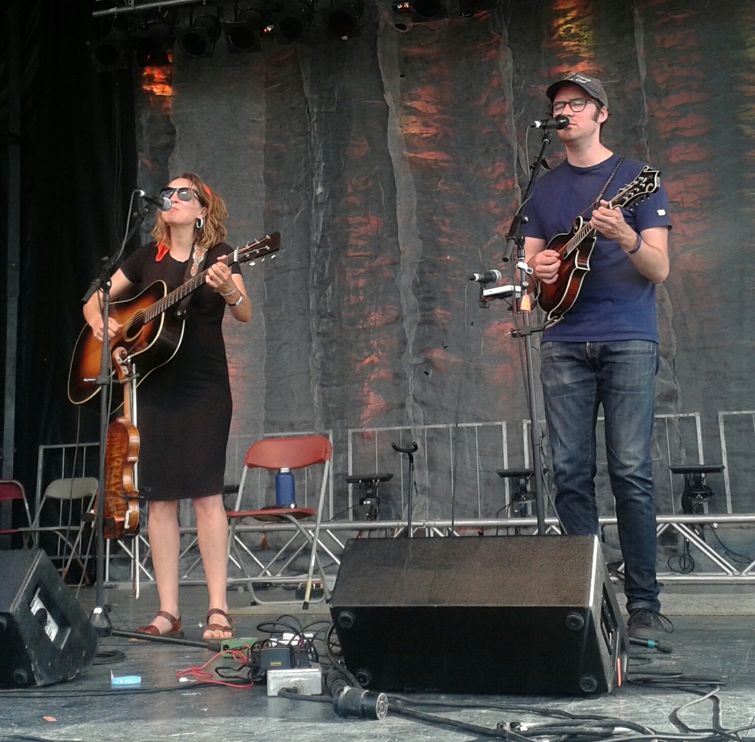 Two musicians performing on stage with guitar and mandolin